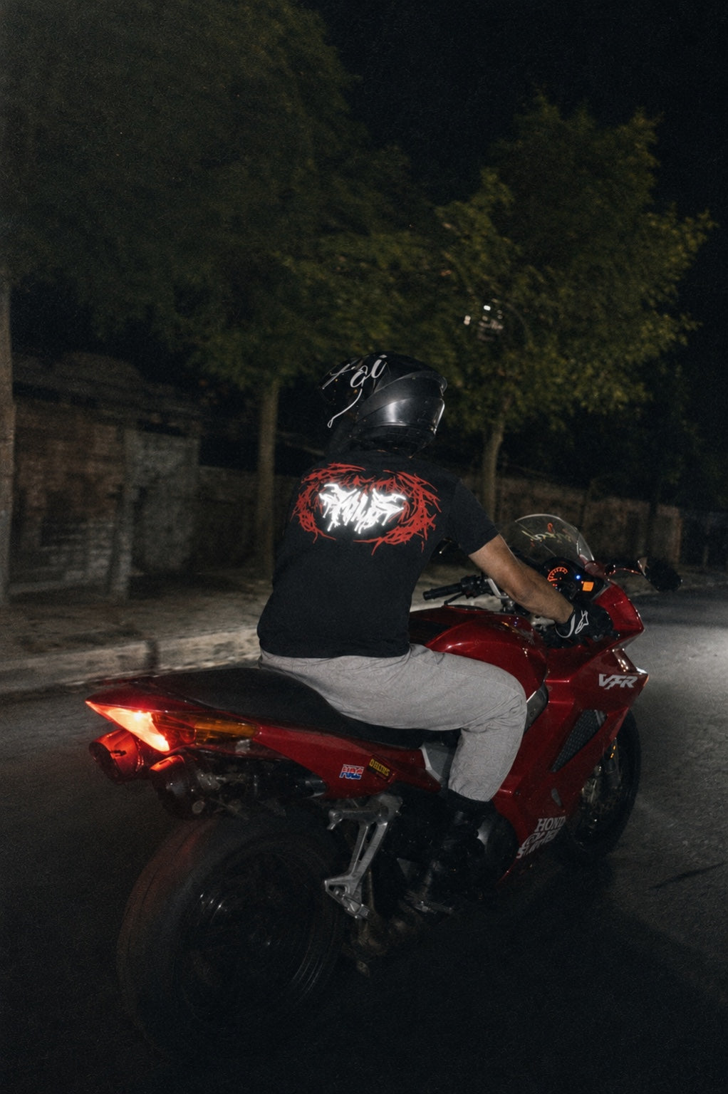 POLE reflective shirt on a red motorcycle at night
